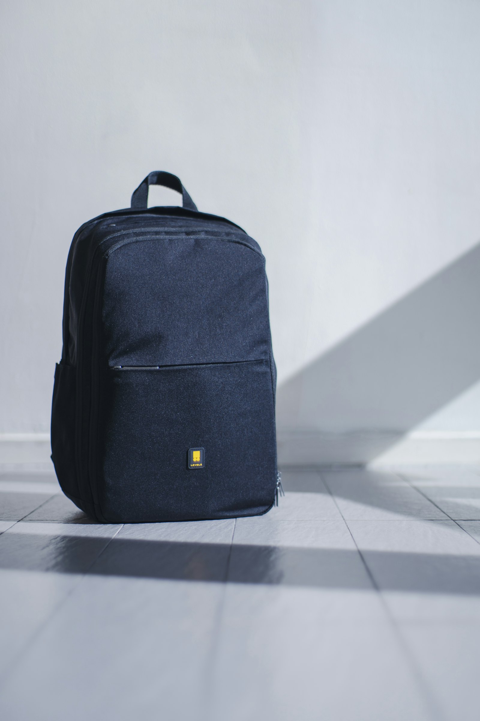 Open carry-on backpack on a bed with neatly folded clothes, a laptop, and a small dop kit