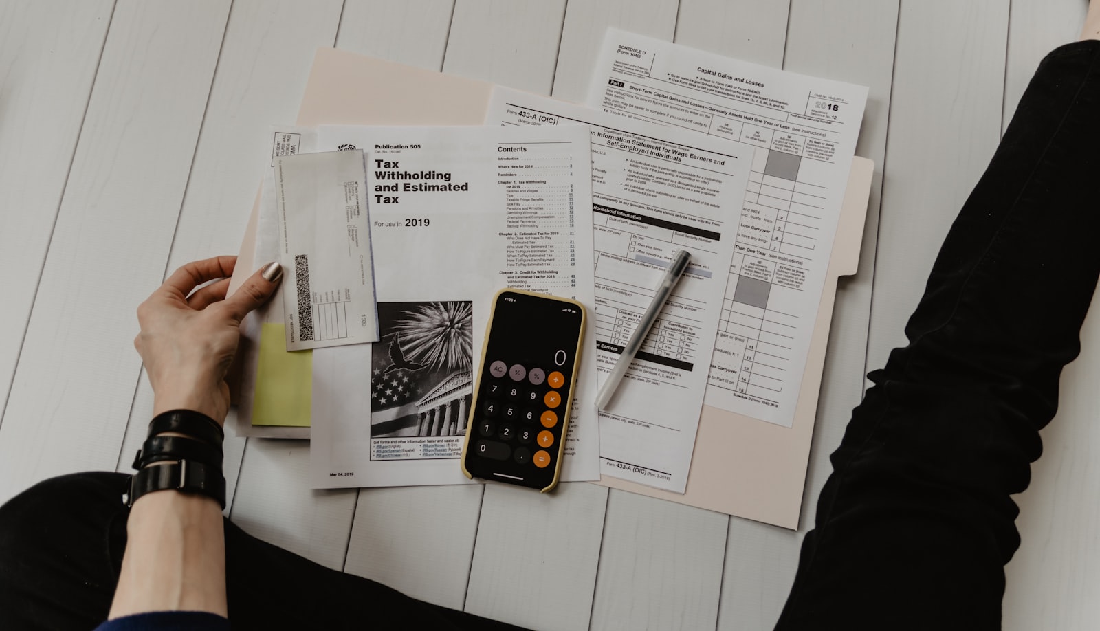 Open paperwork with a calculator and a coffee, suggesting an end-of-year tax filing scene